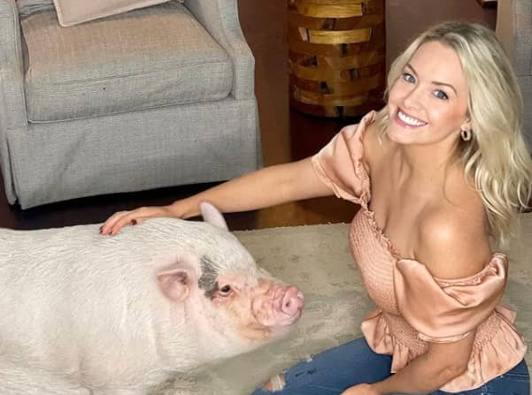 Jenna Cooper with a white pig