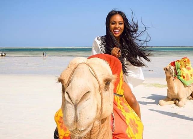   Trina Njoroge rides on a camel 