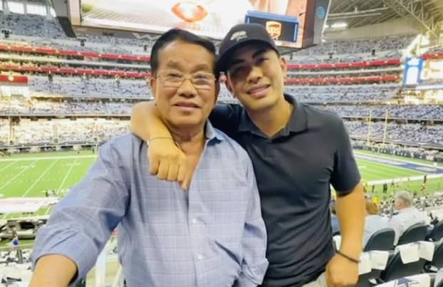 Washington Ho with his dad in a football stadium